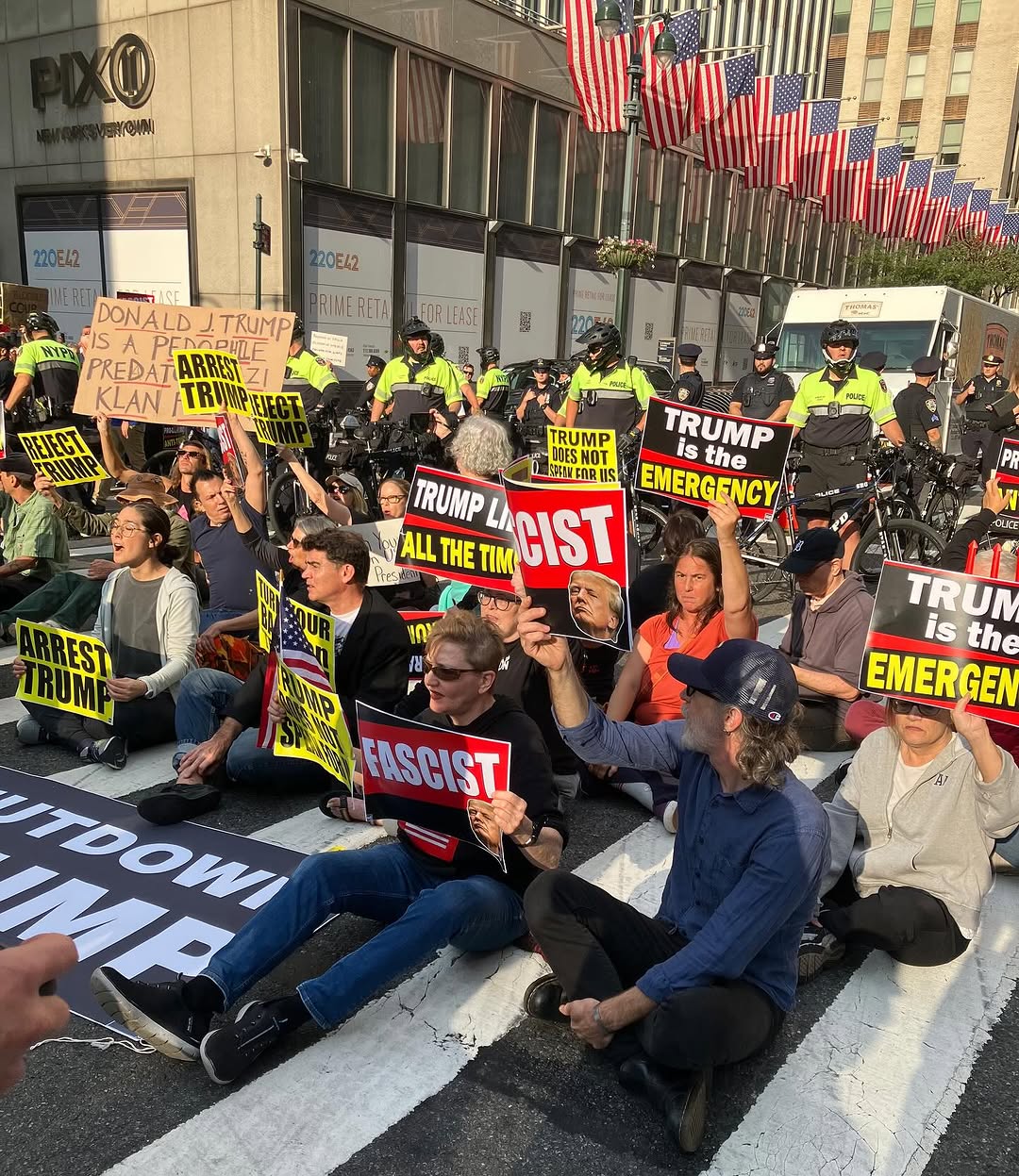Rar and friends leading a sit in on 42nd street in new York city. Folks are sitting in the crosswalk to block Trump's motorcade and holding signs and banners denouncing Trump as a fossil fueled fascist.