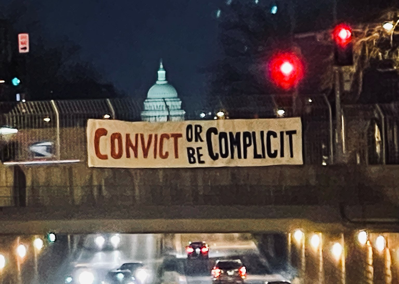 convict or be complicit banner near the capitol