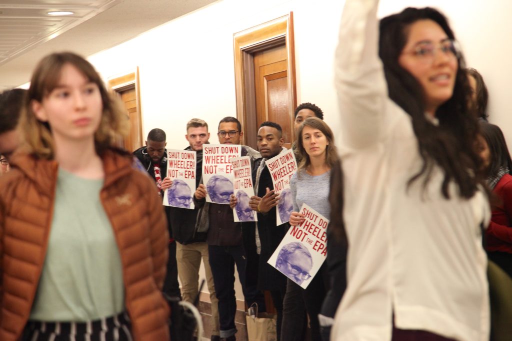 Silent protestors hold signs while emily and other FOE friends are arrested for refusing to be quiet