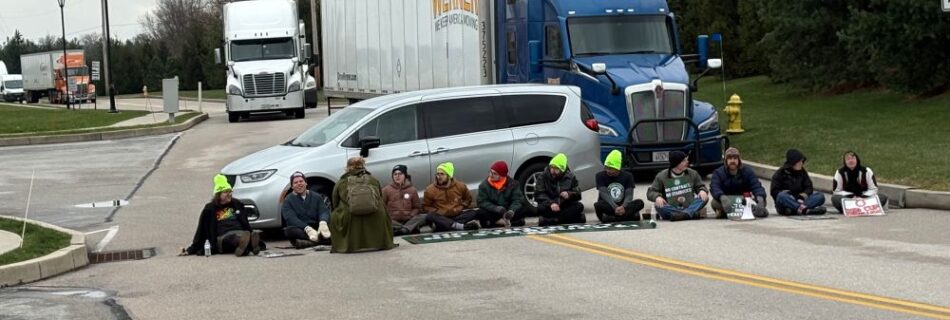 Starbucks workers in York PA sit down in the road, blocking a huge semi truck behind them