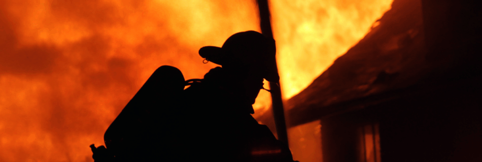A firefighter silhouetted against a burning house under the words "insure our future not fossil fuels & climate chaos"
